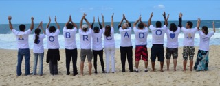 Membros da associação na praia vestindo camisetas que soletram a palavra "obrigado" Membros da associação na praia vestindo camisetas que soletram a palavra "obrigado"